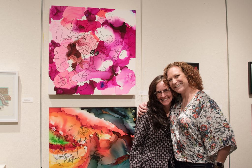 Annual Student Exhibition, 2018: Opening Reception; Art Teaching Professor Sandy Brunvand with her student Leah Caldwell, winner of Best in Show and the Union Purchase award, with her paintings "Connection" (winner, top) and "Endure"